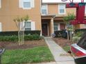 Inviting townhome with well-maintained grounds, lush greenery, and a clear pathway to the front door at 1010 Chelsea Dr, Davenport, FL 33897