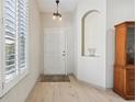 Bright foyer with hardwood floors, a decorative niche, and a view of the front door at 1022 Saint Ives Ct, Mount Dora, FL 32757