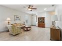 Inviting living room with light wood floors, ceiling fan, and comfortable seating at 1022 Saint Ives Ct, Mount Dora, FL 32757