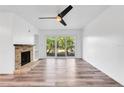 Bright living room featuring wood floors, a stone fireplace, ceiling fan, and sliding glass doors at 1051 S Highland St # 4B, Mount Dora, FL 32757