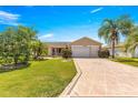 Charming single-story home featuring a two-car garage, screened in porch and tropical landscaping at 1089 Nash Loop, The Villages, FL 32162