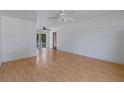Bright living room with light hardwood floors, two ceiling fans, and sliding glass doors at 11987 Se 95Th Ter, Belleview, FL 34420