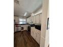 Classic kitchen featuring white cabinets, appliances, countertops, and wood-look flooring at 121 Maple Dr, Debary, FL 32713