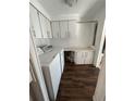 Functional laundry room with white cabinets, countertop space, and a modern washer and dryer set at 121 Maple Dr, Debary, FL 32713