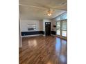 Bright living room featuring wood-look floors, natural light from large windows, and a ceiling fan at 121 Maple Dr, Debary, FL 32713
