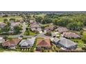 An aerial view displays community streets, well-maintained lawns, and mature trees at 1210 Weaton Ct, The Villages, FL 32162