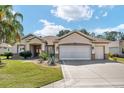 Charming single Gathering home with a well manicured lawn and a beautiful blue sky in the background at 12511 Se 91St Terrace Rd, Summerfield, FL 34491