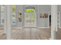 Grand foyer with double doors, high ceilings, natural light, and light colored wood-look flooring at 13112 Luntz Point Ln, Windermere, FL 34786