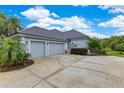 Exterior shot showcasing a three-car garage with matching siding and well-kept driveway at 13112 Luntz Point Ln, Windermere, FL 34786
