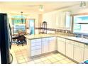 Bright kitchen with tile floors, granite countertops, white cabinets, and breakfast nook at 1312 Corona Ave, The Villages, FL 32159