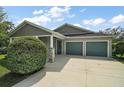 Charming home featuring gray siding, a spacious driveway, and a well-kept lawn and shrubbery at 137 E Palmetto Ave, Howey In The Hills, FL 34737