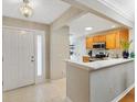 Bright foyer adjacent to a kitchen with light wood cabinets and modern appliances at 1561 Loris Loop, The Villages, FL 32162