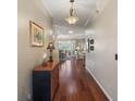 Long hallway with hardwood floors, decorative lighting and wall art leading to the dining room and living room at 1723 Carrera Dr, The Villages, FL 32159