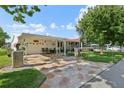Lovely home with a covered carport, front patio, and beautifully patterned driveway at 1901 Brookside Dr, Mount Dora, FL 32757
