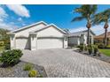 Beautiful home with well-maintained landscaping, a paver driveway, and a spacious two-car garage at 1992 Hagood Loop, The Villages, FL 32162