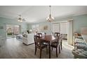 Open-concept living room with dining area, light wood floors, slider to patio, and comfortable seating at 2471 Yalaha Ave, The Villages, FL 32162