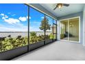 Spacious screened porch offering serene water views of the lake and lush backyard landscaping and covered seating area at 251 Blue Cypress Dr, Groveland, FL 34736