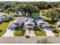 Aerial view of a well-maintained home in a lovely neighborhood with lush greenery and mature trees at 26032 Newcombe Cir, Leesburg, FL 34748