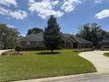Well maintained lawn, flowerbeds, and mature landscaping surround the brick home in this picturesque outdoor shot at 2756 Sequoyah Dr, Haines City, FL 33844