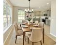 Dining room with modern chandelier, table set for six, and adjacent kitchen view at 3275 Oak Brook Ln, Eustis, FL 32736