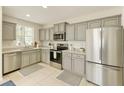 Bright kitchen with stainless steel appliances, neutral cabinets, and tile flooring at 3275 Oak Brook Ln, Eustis, FL 32736