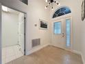 Bright entryway featuring tile flooring, a modern light fixture, and a decorative front door with sidelights at 3684 Eversholt St, Clermont, FL 34711