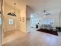 Open-concept living space with tile flooring, modern light fixtures, and a view into the kitchen and dining area at 3684 Eversholt St, Clermont, FL 34711
