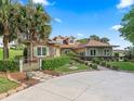 Beautiful home with stone accents, well-manicured landscaping, and a circular driveway, offering curb appeal and charm at 39023 Griffin Lndg, Lady Lake, FL 32159