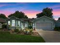 Charming one-story home with beautiful landscaping, lush lawn, and a screened two-car garage during twilight at 4717 Inverness Dr, Leesburg, FL 34748