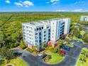 View of the building featuring coastal greenery, private parking and tropical foliage at 5300 S Atlantic Ave # 16-202, New Smyrna Beach, FL 32169