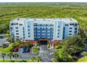 Aerial view of building featuring coastal scenery, private parking, a covered entrance and lush tropical foliage at 5300 S Atlantic Ave # 16-202, New Smyrna Beach, FL 32169
