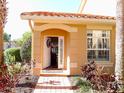 Inviting entrance with an open door, complemented by lush landscaping at 5375 Compass Pt # 04, Oxford, FL 34484