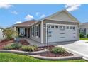 A charming home showcases a two-car garage, inviting front patio, and a meticulously maintained front yard at 5702 Grimes Ct, The Villages, FL 32163