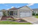 Single Gathering home featuring a 2-car garage, an inviting front patio, and meticulously maintained landscaping at 5702 Grimes Ct, The Villages, FL 32163