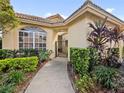 Close-up view of a house entrance, showcasing arched windows and mature landscaping at 9027 Saint Andrews Way, Mount Dora, FL 32757