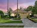 Charming single-story home featuring a tile roof, two-car garage, and well-manicured landscaping at 9027 Saint Andrews Way, Mount Dora, FL 32757
