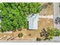 Birds eye view of a single-story home with a neutral-toned roof nestled amongst lush, mature trees at 1109 Hampton St, Clermont, FL 34711