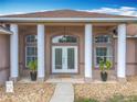 Close-up of the front entrance, featuring decorative pillars, double doors, and stylish lighting at 13013 County Road 561A, Clermont, FL 34715