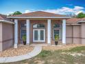 Elegant entrance with pillars and double doors, enhanced by decorative landscaping at 13013 County Road 561A, Clermont, FL 34715