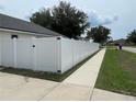 White vinyl fence encloses the private backyard and sidewalk, enhancing privacy and appeal at 1313 Lake Idamere Blvd, Tavares, FL 32778