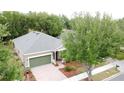 Bird's eye view of a well-maintained home featuring a manicured lawn, brick driveway, and a cozy front porch at 135 Crepe Myrtle Dr, Groveland, FL 34736