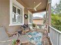 Relaxing front porch with comfortable seating, floral accents, and a ceiling fan, perfect for enjoying the outdoors at 135 Crepe Myrtle Dr, Groveland, FL 34736