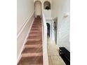 Foyer with a carpeted staircase, tiled floor, and arched doorway at 1420 Kissimmee Ct, Kissimmee, FL 34759