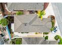 Overhead view of a single-Gathering home featuring a neutral roof, tropical landscaping, and a paved driveway with an parked car at 1536 Barnwell Pl, The Villages, FL 32162