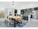 Modern kitchen featuring dark cabinets, stainless steel appliances, a large island, and an adjacent dining area at 161 Williamson Dr, Davenport, FL 33897
