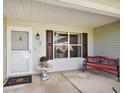 Inviting front porch with red bench and decorative accents at 1733 Oakville Pl, The Villages, FL 32162