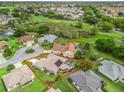 Aerial view of a home with a backyard pool overlooking a golf course and lush green surroundings at 1804 Estafana Way, The Villages, FL 32159