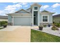 Beautiful single-Gathering home featuring a well-manicured lawn, light blue exterior, and attached two-car garage at 1966 Wallingford Loop, Mount Dora, FL 32757