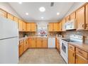 Well-lit kitchen features ample cabinet space, tiled floors, and appliances for a functional cooking area at 2042 Hydrangea Ave, The Villages, FL 32162