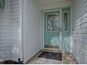 Charming aqua front door with glass window feature and black welcome mat at 2103 Patino Ln, The Villages, FL 32159